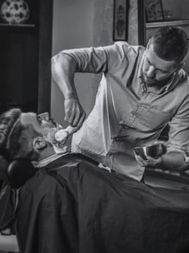 the barber shaves the beard foto